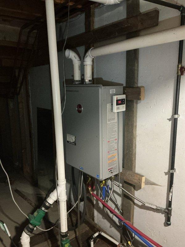 Responded to service call for Rheem tankless water heater (model EZOH200DVLKL2) displaying error code 99 with blinking display and no hot water delivery. Upon inspection, diagnosed system malfunction related to temperature sensor or control board issue causing false temperature reading. Performed troubleshooting procedures, reset unit controls, verified proper operation of circulator pump and plumbing connections, and restored hot water flow to system.