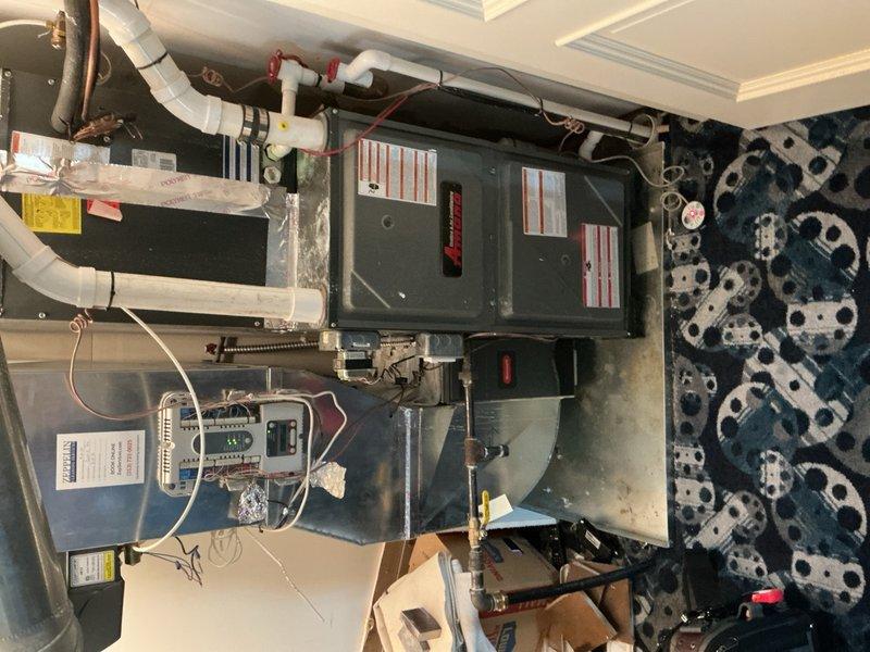 Responded to service call for 9-year-old furnace unit located in movie room with reported leak and operational failure. Upon arrival, conducted thorough visual inspection of air handler system, condensate drainage lines, and associated PVC piping. Identified leak source in condensate drain system and assessed overall unit functionality. Inspected electrical connections, control panel wiring, and safety labels for compliance. Examined ductwork insulation, copper refrigerant lines, and blower assembly for signs of damage or deterioration. Documented equipment condition through photographic evidence showing unit installation, drainage configuration, and mechanical components. Provided homeowner with findings and recommended next steps for repair to restore proper heating operation.