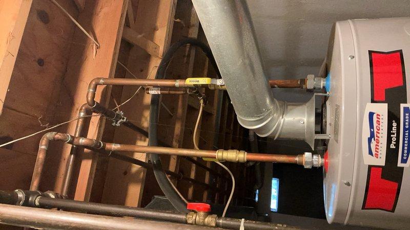 Completed comprehensive air conditioning tune-up on 10+ year old system with air handler located in basement. Performed full system inspection including condenser unit evaluation, refrigerant level check, electrical connection testing, and airflow assessment. Replaced air filters with new pleated media filters to ensure optimal system performance and indoor air quality. Inspected water heater connections, copper piping, ductwork, and all mechanical components in utility area. System found operational and working properly at time of service. Documented equipment condition with photographs of mechanical room showing ProLine water heater, copper plumbing lines with brass fittings, galvanized ductwork, and filter replacement. All components functioning within normal parameters for equipment age.