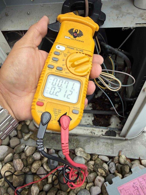 Responded to no cooling condition on 23-year-old air conditioning system. Upon arrival, performed electrical diagnostics using digital multimeter to test voltage and amperage at outdoor unit components. Testing revealed failed dual-run capacitor rated at 440VAC, which was preventing compressor and condenser fan motor from starting. Replaced defective capacitor with properly rated replacement, verified all electrical connections, and confirmed system returned to normal operation with proper voltage readings and both compressor and fan motor running.