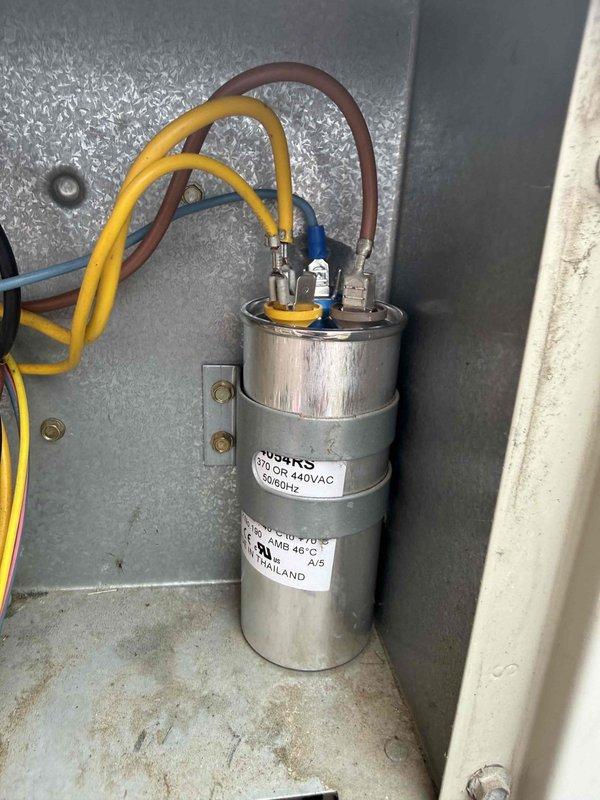 Responded to no cooling condition on 23-year-old air conditioning system. Upon arrival, performed electrical diagnostics using digital multimeter to test voltage and amperage at outdoor unit components. Testing revealed failed dual-run capacitor rated at 440VAC, which was preventing compressor and condenser fan motor from starting. Replaced defective capacitor with properly rated replacement, verified all electrical connections, and confirmed system returned to normal operation with proper voltage readings and both compressor and fan motor running.