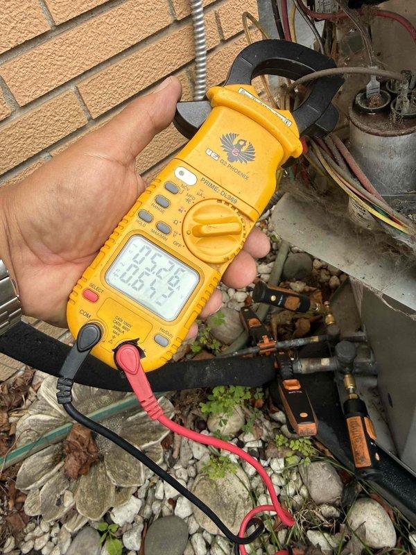 Responded to no airflow complaint on 10-year-old split system with ice buildup on suction line. Found condenser and air handler operating but system experiencing refrigerant freeze-up at multiple points along insulated refrigerant piping. Performed diagnostic testing using digital multimeter to check electrical components and capacitor operation at outdoor condensing unit. System likely experiencing low refrigerant charge or restricted airflow causing evaporator coil to ice over, resulting in blocked air distribution through vents.