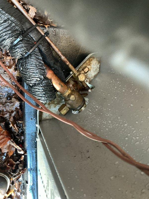 Completed Gold AC Inspection on two residential air conditioning systems - one 30-year-old unit located in basement and one unit of unknown age in attic space accessed through third-floor crawl entry. Performed comprehensive maintenance including filter inspection, refrigerant level checks, electrical connection testing, condensate drain evaluation, and airflow measurements on both systems. 

Basement unit inspection revealed aging copper refrigerant lines with significant green patina oxidation and corrosion buildup, indicating prolonged moisture exposure. Flexible ductwork showed heavy dust accumulation. Mineral deposits and debris observed on brass fittings and surrounding components. Documented deteriorated condition of 30-year-old system components with photographic evidence.

Exterior disconnect box inspected on basement system - verified proper operation of Inverter-Duty rated disconnect switch, confirmed both line fuses operational with indicator lights functioning correctly, i