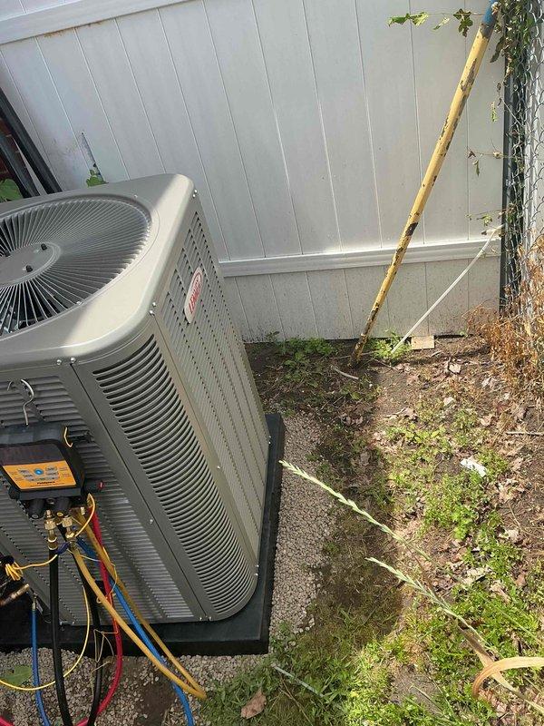 Completed installation of 2-ton air conditioning system with evaporator coil in residential property. Positioned outdoor condenser unit on concrete pad against exterior wall with proper refrigerant line connections and secured all copper piping with appropriate insulation. Indoor evaporator coil was installed and integrated with existing furnace system in garage utility space, ensuring proper airflow configuration and drainage connections. All electrical disconnects, refrigerant lines, and condensate drainage were installed per manufacturer specifications and local mechanical permit requirements. System was charged, leak-tested, and commissioned to verify proper operation and cooling performance.