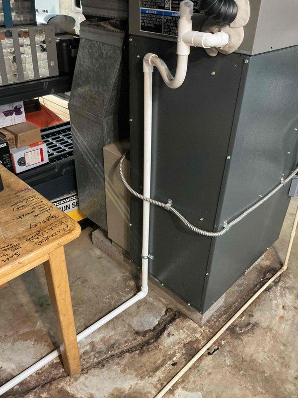 Completed installation of 2-ton air conditioning system with evaporator coil in residential property. Positioned outdoor condenser unit on concrete pad against exterior wall with proper refrigerant line connections and secured all copper piping with appropriate insulation. Indoor evaporator coil was installed and integrated with existing furnace system in garage utility space, ensuring proper airflow configuration and drainage connections. All electrical disconnects, refrigerant lines, and condensate drainage were installed per manufacturer specifications and local mechanical permit requirements. System was charged, leak-tested, and commissioned to verify proper operation and cooling performance.