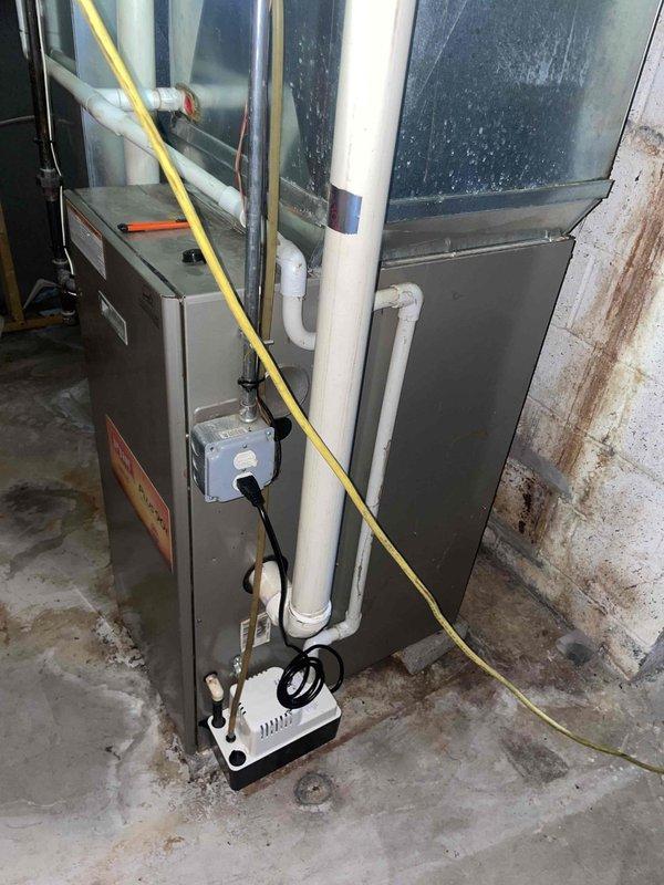 Provided estimate for replacement of R-22 air conditioning system and furnace, with primary focus on AC unit replacement. Assessed existing basement-installed HVAC equipment including furnace and cooling system with vertical ductwork extending to attic space. Evaluated current system configuration, drainage components including condensate pump, and electrical connections to determine replacement specifications for natural gas furnace and compatible air conditioning unit.