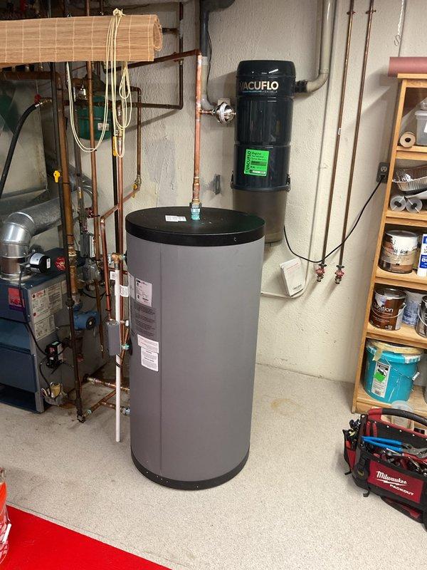 Completed installation of indirect water heater system in residential basement utility room. Installed large-capacity cylindrical storage tank with integrated pump unit, configured all copper supply and return piping with appropriate shut-off valves, pressure relief mechanisms, and connection fittings to existing boiler system. Applied for and coordinated mechanical permit for hot water heater reconnection, processed payment, and documented completed installation with photographs showing proper plumbing configuration and professional-grade workmanship.