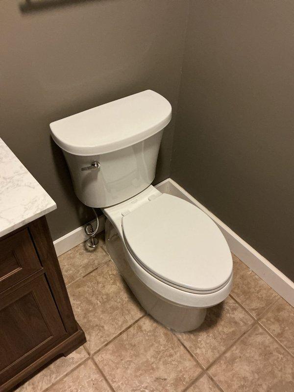 Completed toilet installation in residential bathroom, securing unit to flange and connecting water supply line. Verified proper flush operation, checked for leaks at all connection points, and confirmed stable mounting to ensure optimal performance.