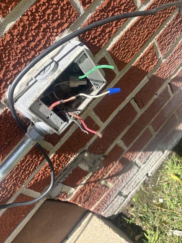 Responded to service call for malfunctioning exterior light fixture mounted on brick wall. Upon inspection, found weathered electrical junction box with exposed and improperly terminated wiring, including disconnected ground, neutral, and hot conductors. Assessed fixture and electrical box condition, documented existing wiring configuration and code compliance issues. Provided recommendations for fixture replacement and proper electrical connection repair to restore safe operation of exterior lighting system.