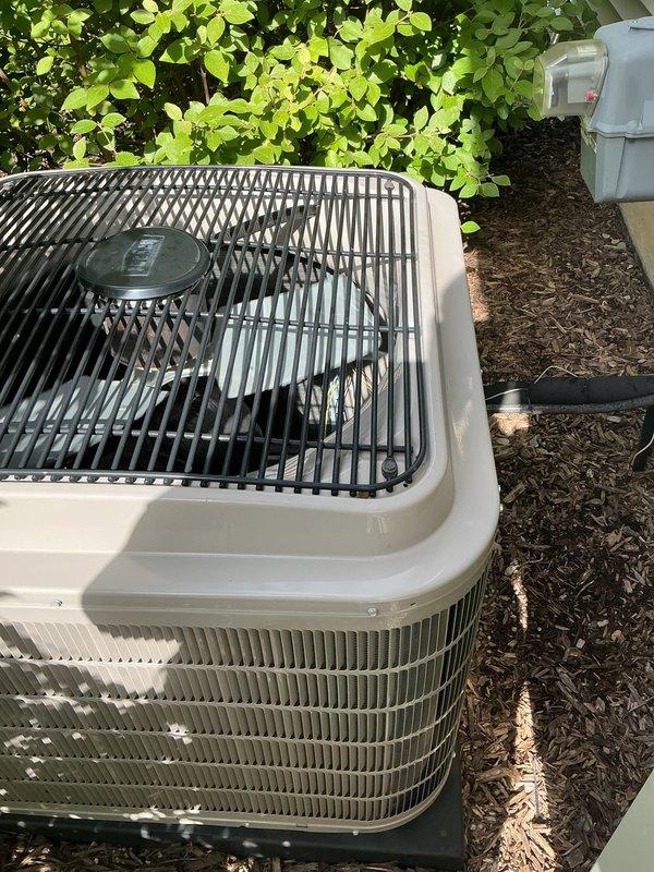 Completed comprehensive Gold AC inspection on 5-year-old residential air conditioning system with air handler located in basement and condenser unit positioned in exterior landscaped area. Performed electrical diagnostics and measurements at indoor air handler using digital testing meter to verify proper voltage, amperage, and system controls. Inspected outdoor condenser unit, confirmed clear airflow through cabinet louvers and top discharge grille, verified fan motor operation, and ensured surrounding area was free of debris with adequate clearance from landscaping. All system components found operating within normal parameters with no service concerns identified at time of inspection.