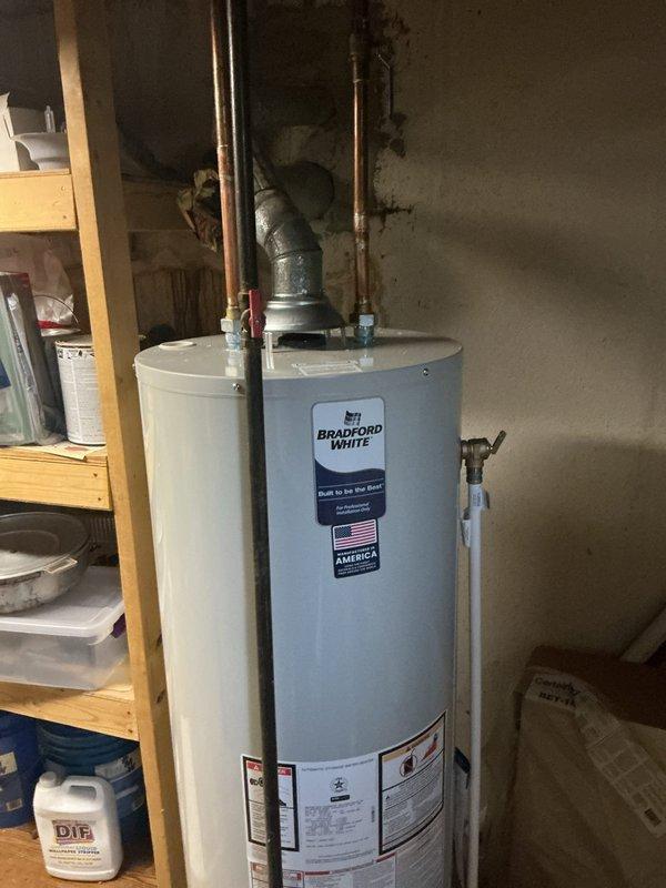 Installed a new 40-gallon Bradford White tanked water heater in basement utility area, completing all necessary plumbing connections with copper piping and pressure relief valve installation. Reconnected hot water supply lines and verified proper operation of all fixtures, including testing water flow at kitchen/bathroom faucets to ensure adequate hot water delivery throughout the residence.