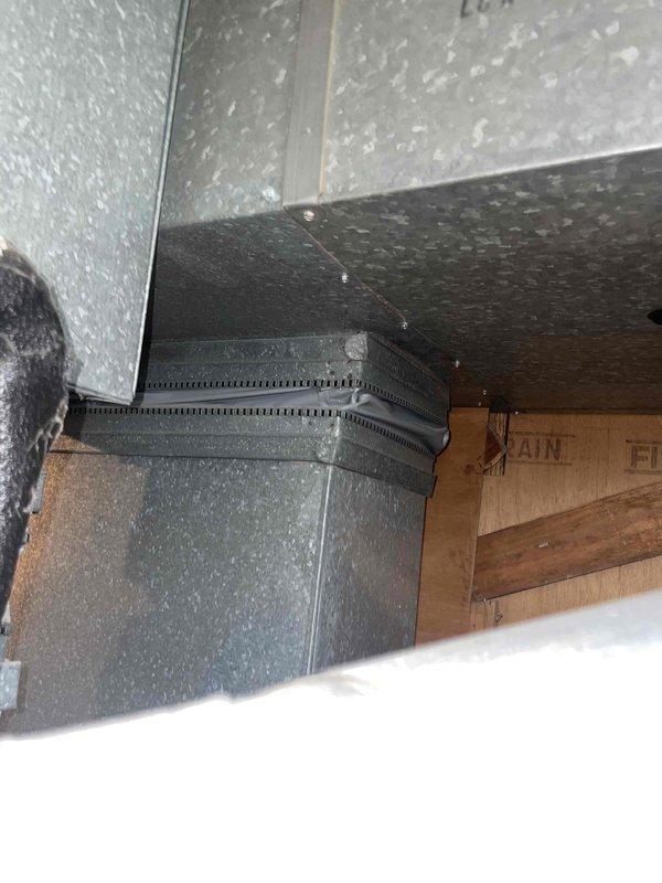 Responded to service call for malfunctioning thermostat and air conditioning system failing to adequately cool residence, with indoor temperature remaining at approximately 83°F despite continuous system operation. Conducted comprehensive system evaluation including inspection of indoor air handler, ductwork, and outdoor condensing unit. Assessed thermostat functionality and age, noting unit located in living room near front entrance. Evaluated outdoor condenser accessibility, identifying restricted airflow due to overgrown climbing hydrangea vegetation in close proximity to unit, which may be contributing to reduced cooling efficiency and inadequate heat rejection. Documented existing site conditions including tight clearances around outdoor equipment, nearby gutter system, and flower border potentially impacting service access and proper ventilation requirements. Inspected attic space and examined air distribution system components, including supply ductwork and insulation installati