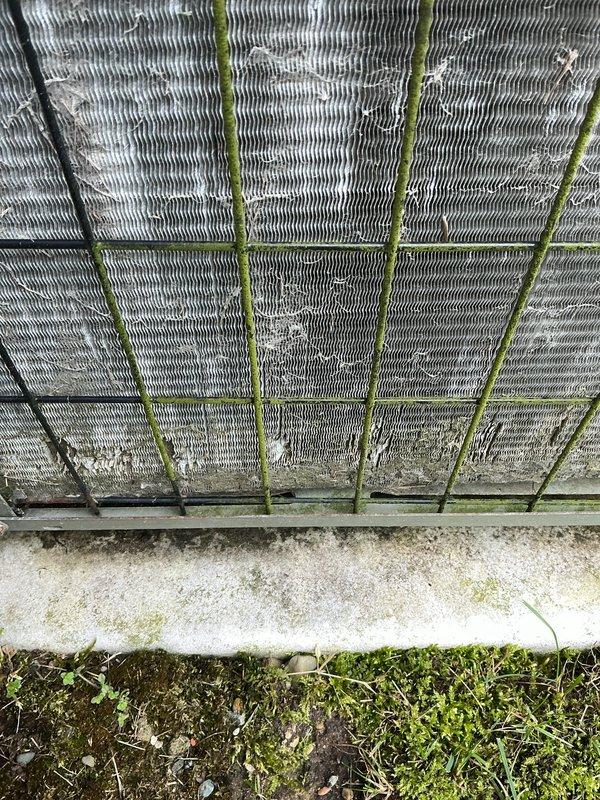 Completed Gold AC inspection on Carrier system with air handler located in basement. Replaced humidifier tube orifice as part of routine maintenance. Outdoor condenser unit exhibited heavy biological growth including moss and algae accumulation on coil fins and vertical supports, along with significant mineral deposits and debris buildup affecting heat transfer efficiency. Noted extensive rust staining on fan guard and top panel around motor hub, indicating prolonged moisture exposure. Condenser coils showed corrugation pattern with discoloration throughout and organic matter accumulation requiring attention. Unit operational at time of inspection with refrigerant lines properly secured to exterior wall. Recommended professional coil cleaning to restore optimal airflow and system efficiency due to heavy contamination of heat exchanger surfaces.