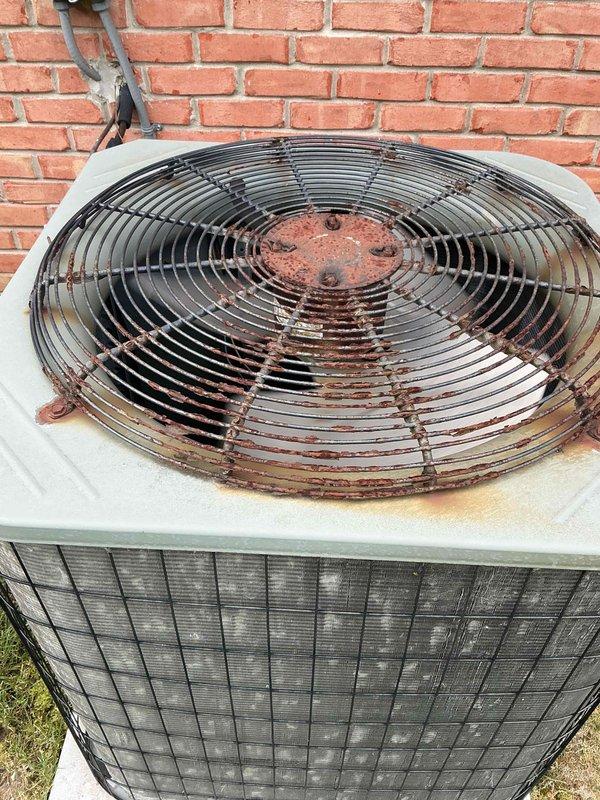 Completed Gold AC inspection on Carrier system with air handler located in basement. Replaced humidifier tube orifice as part of routine maintenance. Outdoor condenser unit exhibited heavy biological growth including moss and algae accumulation on coil fins and vertical supports, along with significant mineral deposits and debris buildup affecting heat transfer efficiency. Noted extensive rust staining on fan guard and top panel around motor hub, indicating prolonged moisture exposure. Condenser coils showed corrugation pattern with discoloration throughout and organic matter accumulation requiring attention. Unit operational at time of inspection with refrigerant lines properly secured to exterior wall. Recommended professional coil cleaning to restore optimal airflow and system efficiency due to heavy contamination of heat exchanger surfaces.