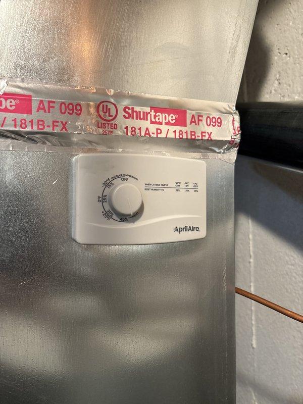 Completed full HVAC system installation including a 90,000 BTU furnace with left-side configuration and 2.5 ton air conditioning unit in residential utility space. Installed new thermostat and reconnected existing humidifier (AprilAire unit with digital control) to new system. All ductwork connections secured with proper sealing, mechanical and electrical permits obtained, and system tested for proper operation upon completion.