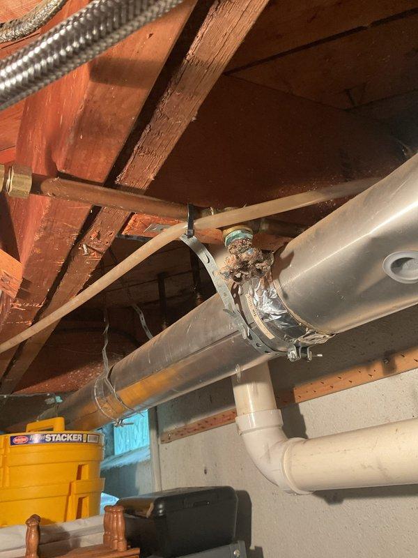 Responded to a water leak originating from a corroded brass valve connection on a supply line in the basement ceiling of a 65-year-old home. Upon inspection, discovered significant mineral deposits and rust deterioration at the valve fitting, which had compromised the seal and caused active water seepage into the affected area below. Shut off the water supply, removed the deteriorated valve assembly, cleaned the threaded connections, and installed a new brass valve with proper thread sealant to restore system integrity. Tested the repair under full pressure to confirm no further leakage and verified proper operation of all connected fixtures.