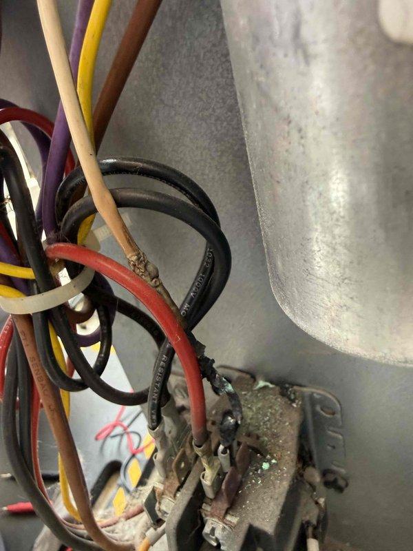 Responded to service call for 13-year-old air conditioning system experiencing short cycling with inadequate cooling. Upon arrival, performed comprehensive diagnostic inspection of outdoor condenser unit located in backyard. Visual examination revealed severely deteriorated electrical connections at the contactor assembly, with extensive corrosion, oxidation, and rust buildup on terminal points. Multiple control wires displayed signs of aging including frayed insulation, discoloration, and compromised connections that could cause intermittent electrical faults leading to short cycling behavior. Documented equipment condition with photographic evidence showing corroded terminals and degraded wiring harnesses. Given the advanced age of the system and extent of electrical deterioration observed, provided assessment of current equipment condition and discussed repair versus replacement options with homeowner to address the short cycling issue and restore proper cooling operation.