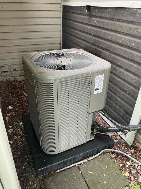 Completed comprehensive Gold AC inspection on 3-year-old residential air conditioning system with outdoor condenser unit and air handler/coil located in small entrance attic. Performed thorough visual examination of condenser unit positioned on rubber pad in backyard, noting unit exterior condition, manufacturer specifications, and refrigerant line connections. Inspected evaporator coil fins for cleanliness and proper airflow, confirming no visible corrosion, damage, or debris accumulation on heat exchanger surfaces. Advised property owner that surrounding condenser area requires clearing of organic debris, leaves, and any animal waste to maintain optimal system performance and prevent airflow restriction.