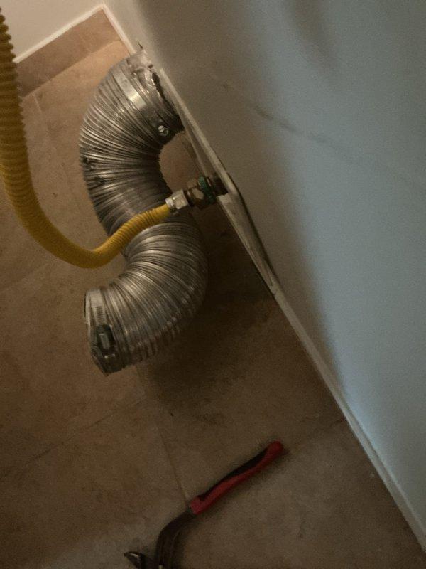 Installed flexible gas line connection to dryer unit, securing all fittings with proper metal clamps and ensuring leak-free operation. Connected yellow corrugated stainless steel tubing from wall outlet to appliance with appropriate shut-off valve and tested system for safety compliance.