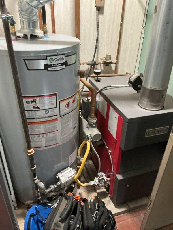 Completed comprehensive inspection and tune-up of 10-year-old boiler system and 2-year-old AO Smith ProLine water heater located in main floor hallway. Verified proper operation of heating unit, inspected all copper piping connections, pressure relief valves, and venting systems for both units. Tested programmable thermostat functionality, confirmed all safety controls operational, and documented equipment condition with no immediate service concerns identified.