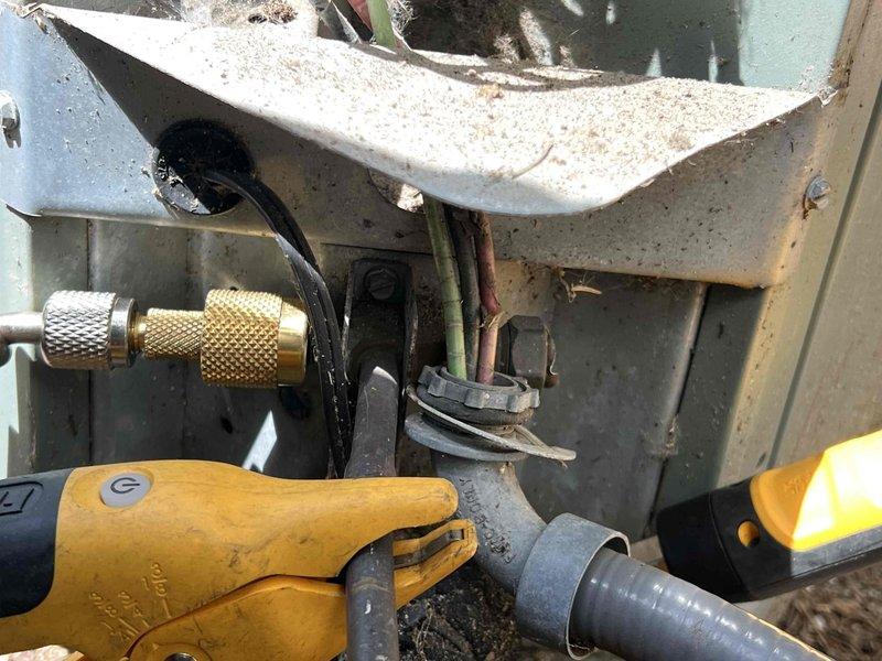 Performed comprehensive AC tune-up and inspection on 15-year-old residential air conditioning unit located in basement. Conducted refrigerant system diagnostics using digital multimeter and pressure testing equipment at outdoor condensing unit, checking service ports and electrical components. System evaluated for proper operation with capacitance readings taken and all mechanical components assessed for wear and functionality.