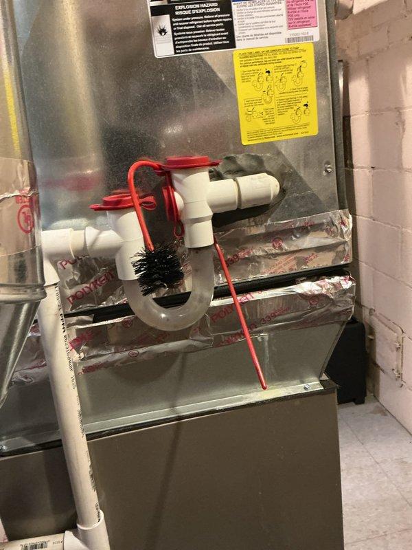 Responded to emergency service call for gas leak on 3-year-old Bryant furnace in basement after utility company shut off gas supply. Upon arrival, inspected furnace and associated gas piping for leak source, examining all connections, valves, and joints. Conducted thorough visual inspection of condensate drainage system including PVC trap assembly and drain pan, which showed evidence of water accumulation and mineral deposits. Documented equipment condition with photographs showing furnace installation, flexible ductwork connections, gas line routing, and condensate management components. Verified all safety labels present and accessible on equipment. Inspected plenum connections and insulated ductwork for proper installation. System remained offline pending gas company clearance for restoration of service after leak repair verification.