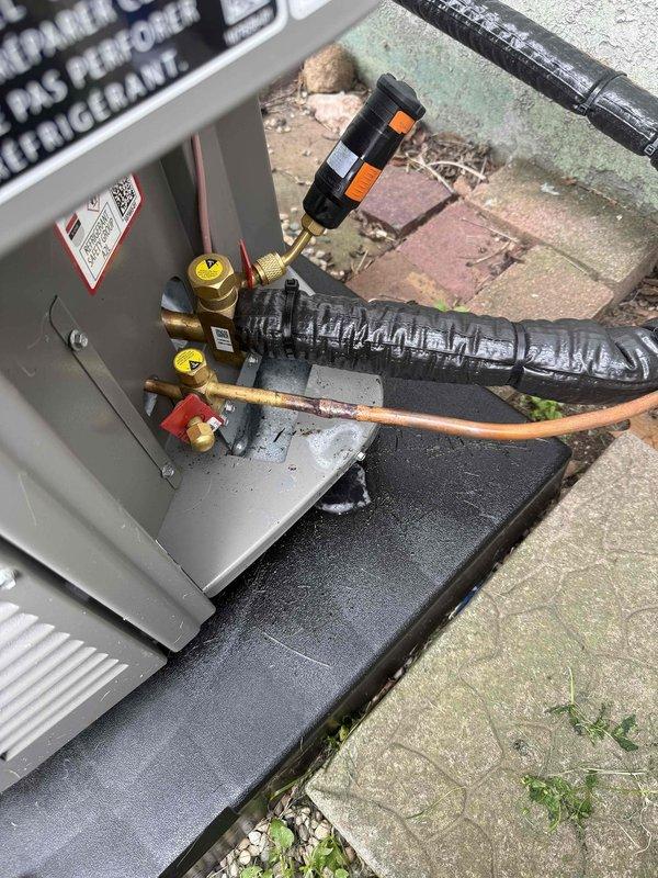 Responded to warranty call for AC unit experiencing short cycling and improper operation. Upon inspection, discovered severe corrosion and deterioration at refrigerant line connection point on outdoor condensing unit. Corroded copper tubing showed moisture accumulation and material breakdown at joint, indicating refrigerant leak causing system to cycle improperly. Documented damaged components with photos showing compromised connection and surrounding refrigerant lines. Accessed service valves and attached manifold gauges to assess system pressures. Unit installed June 2026, located in basement with condensing unit on exterior concrete pad. Corrosion at connection point determined to be manufacturing or installation defect covered under warranty terms. Recommended replacement of affected refrigerant line section and proper brazing of new connection to restore system integrity and resolve cycling issue.