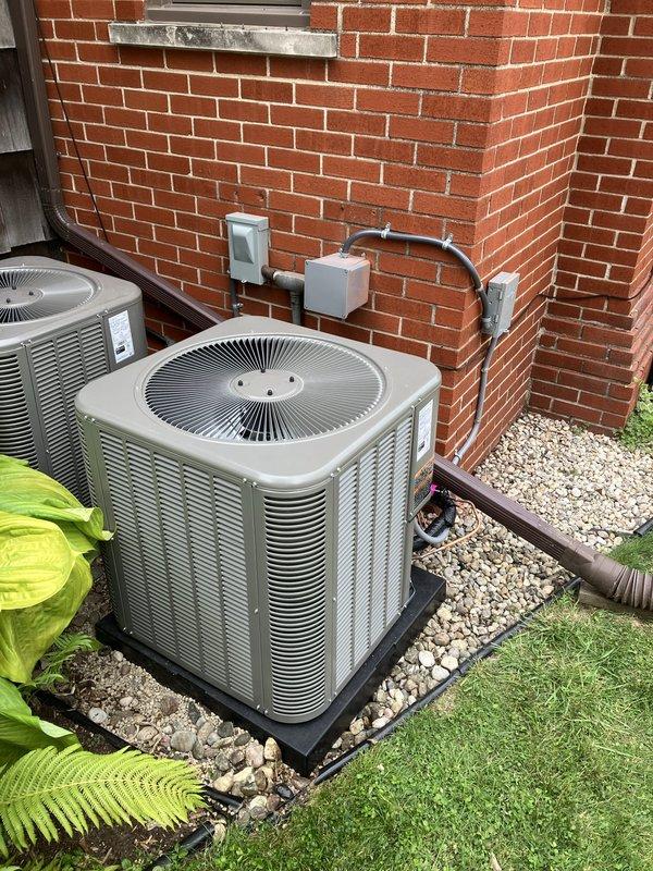 Completed full HVAC system installation including a 70,000 BTU furnace, 2.5-ton air conditioning unit with rear discharge configuration, programmable thermostat, and humidifier reconnection. Both outdoor condensing units were professionally positioned on composite pad bases over gravel drainage beds against exterior brick wall with proper electrical disconnects and conduit installations. System was pressure-tested and charged to manufacturer specifications, with refrigerant pressures verified using digital manifold gauges to ensure optimal performance and efficiency.