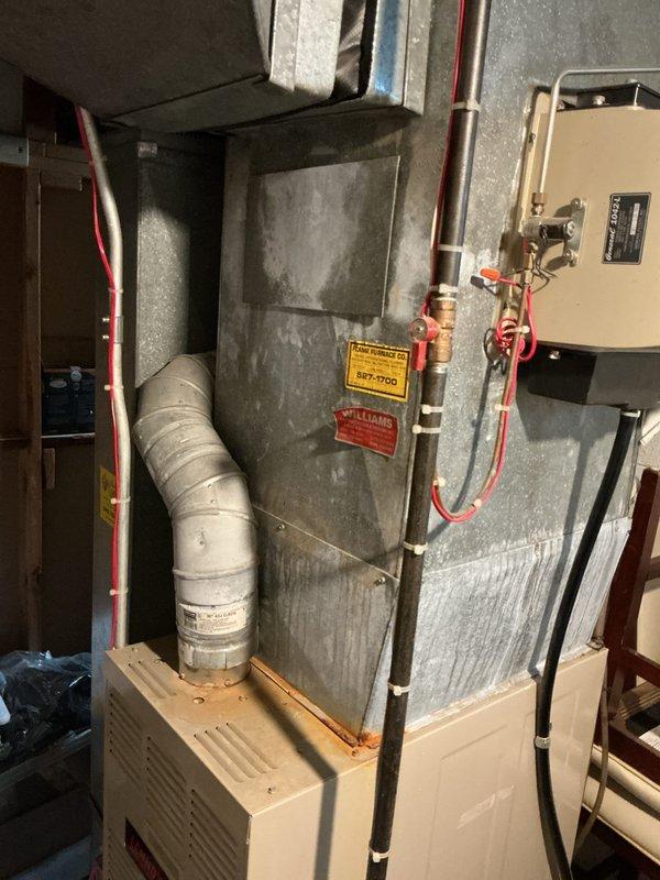 Responded to service call for AC not cooling in basement location. Upon inspection, found 20+ year old system with significant aging and dust accumulation on air handler unit. Performed comprehensive AC tune-up and system evaluation. Assessed overall condition of equipment including air handler, refrigerant lines, electrical components, and condensate pump. Evaluated thermostat functionality showing current temperature differential between set point and actual room temperature. Provided full system estimate for replacement due to age and condition of existing equipment.