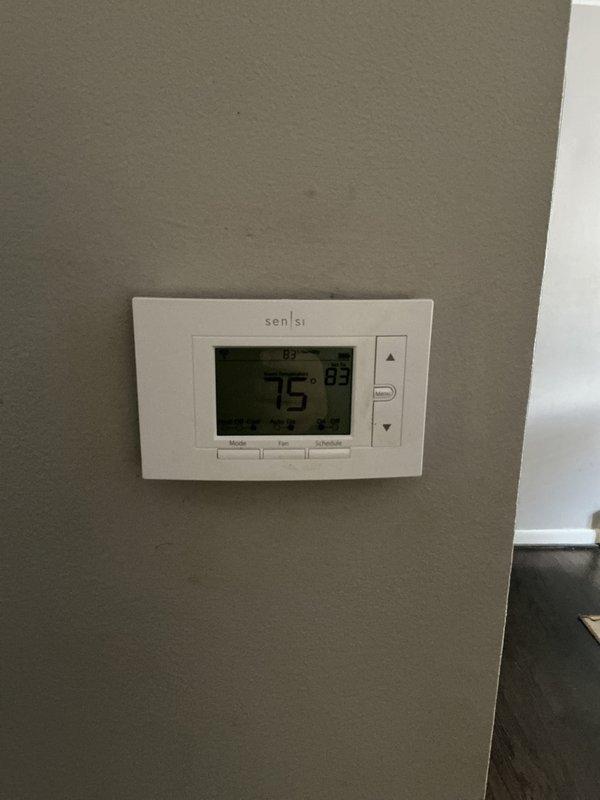 Responded to service call for AC not cooling in basement location. Upon inspection, found 20+ year old system with significant aging and dust accumulation on air handler unit. Performed comprehensive AC tune-up and system evaluation. Assessed overall condition of equipment including air handler, refrigerant lines, electrical components, and condensate pump. Evaluated thermostat functionality showing current temperature differential between set point and actual room temperature. Provided full system estimate for replacement due to age and condition of existing equipment.