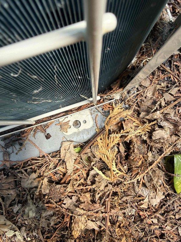 Completed comprehensive tune-up service on 3-year-old Daikin air conditioning condenser unit located in backyard. Performed standard maintenance protocol including system inspection, operational testing, and cleaning of accumulated organic debris (leaves, pine needles, and mulch) from base and lower condenser coil area. Inspected and secured mounting hardware to address reported instability concern, verified unit is properly anchored to concrete pad, and confirmed all mechanical components are functioning within manufacturer specifications.