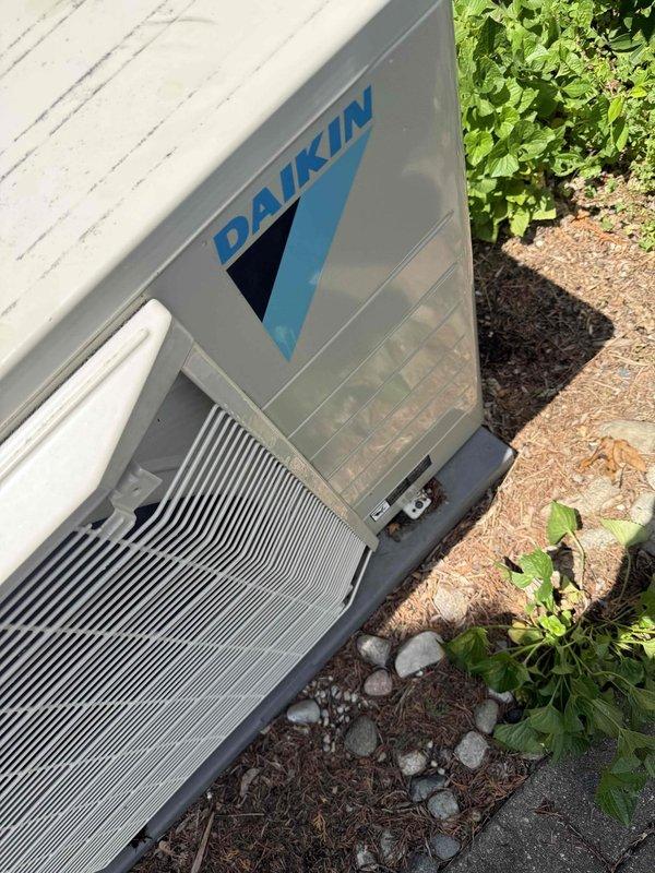 Completed comprehensive tune-up service on 3-year-old Daikin air conditioning condenser unit located in backyard. Performed standard maintenance protocol including system inspection, operational testing, and cleaning of accumulated organic debris (leaves, pine needles, and mulch) from base and lower condenser coil area. Inspected and secured mounting hardware to address reported instability concern, verified unit is properly anchored to concrete pad, and confirmed all mechanical components are functioning within manufacturer specifications.
