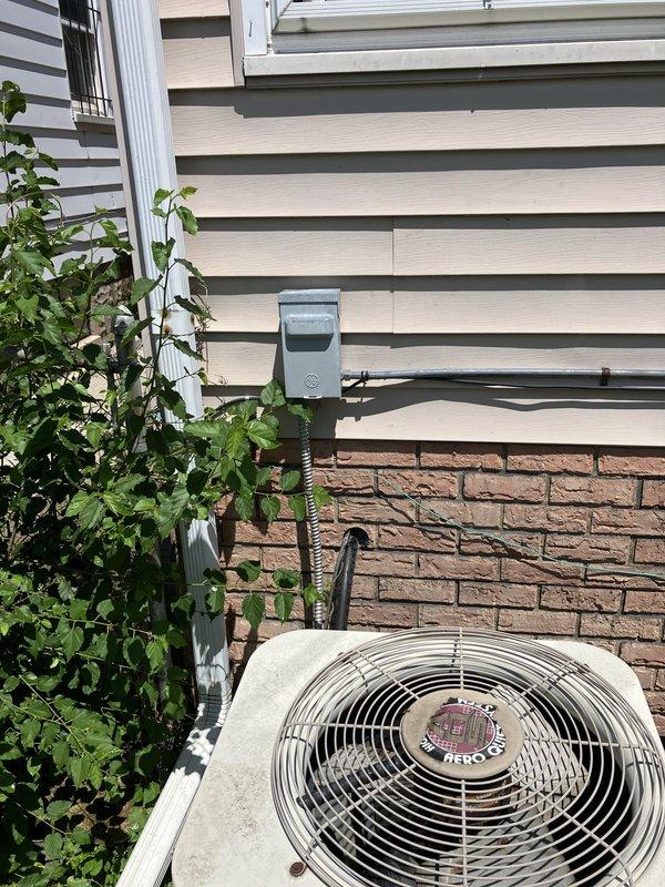 Conducted comprehensive site evaluation for complete HVAC system replacement including new central air conditioning unit and furnace installation. Assessed existing outdoor condenser unit positioned against residential exterior, noting vegetation growth around equipment and current electrical disconnect configuration. Evaluated interior and exterior conditions to determine ductwork requirements and identify potential modifications needed for new system installation. Documented existing equipment specifications and mounting locations through photographic documentation to support proposal development for full system upgrade.