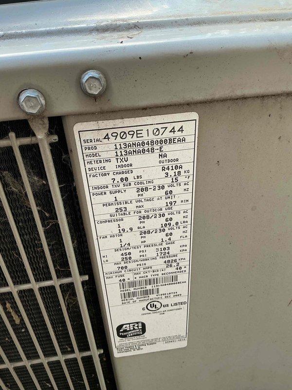 Completed comprehensive Gold AC inspection on Bryant 113ANA048 condenser unit, serial number 4909E10744, utilizing R410A refrigerant with factory charge of 7.08 lbs. Performed full system evaluation including visual inspection of outdoor condenser unit positioned on concrete pad against brick exterior, confirmed proper mounting and clearances. Inspected manufacturer specifications, verified electrical ratings at 208-230 volts AC, 60 Hz, and documented compressor specifications. Evaluated exterior cabinet condition noting age-related weathering consistent with equipment over 10 years old. Assessed indoor air handler located in basement. Documented unit condition through photographic records showing operational equipment with typical wear patterns. System operational at time of inspection with all components accessible and functioning within manufacturer specifications.