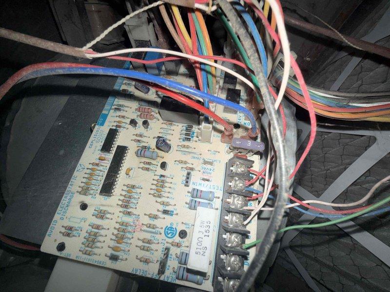 Responded to no cooling complaint on 10-year-old Comfortmaker furnace and air conditioning system located in basement. Upon arrival, confirmed customer reports of loud noises from equipment during operation. Performed diagnostic inspection of both furnace cabinet and AC components. Inspected control board wiring connections and found multiple wire terminals with dust accumulation and signs of age-related wear. Examined furnace cabinet panels, ventilation slots, and exterior components for operational integrity. Documented existing control board configuration showing cream-colored PCB with multiple colored wire connections including red, blue, white, pink, yellow, and green leads connected through terminal blocks. Photographed current system condition including control board placement near ductwork and copper refrigerant lines. Assessed overall equipment status and provided recommendations for addressing noise concerns and ensuring continued system operation.