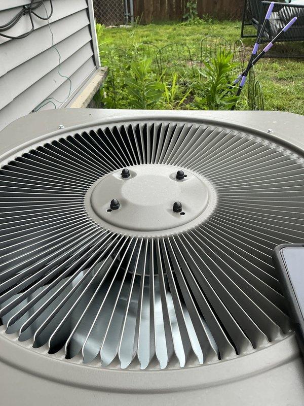 Completed comprehensive Gold AC inspection on residential single-zone air conditioning system less than one year old with air handler located in basement. Performed thorough visual assessment of outdoor condenser unit, documenting equipment condition through detailed photography. Inspection revealed significant accumulation of dirt, dust, and debris on exterior condenser coils and filter surfaces, as well as overgrown vegetation around unit base requiring attention for optimal airflow and system efficiency. Verified system operational status, examined fan assembly and mounting hardware, and assessed overall equipment condition. Unit currently functioning properly despite maintenance needs identified during inspection.