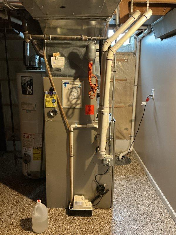 Performed annual AC tune-up and cooling maintenance on 16-year-old Bryant system. During inspection, discovered failed secondary heat exchanger in furnace unit, resulting in system shutdown for safety. Documented existing HVAC equipment configuration including furnace, ductwork, and associated mechanical components in basement utility area.