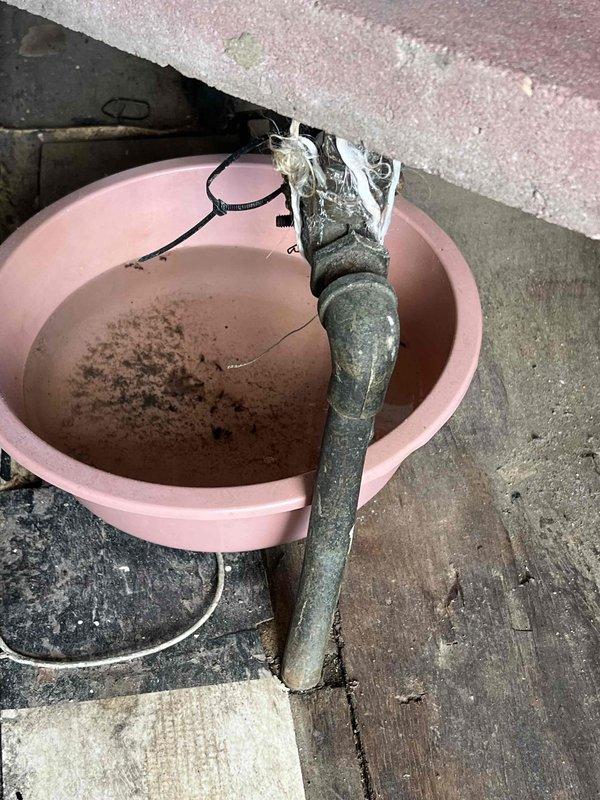 Responded to water leak call for boiler system located in laundry room. Upon inspection, found severely corroded pressure relief valve with active leaking, requiring bucket placement to catch discharge. Removed deteriorated pressure relief valve showing significant mineral deposits and oxidation, then installed new replacement valve with proper threading and sealing to eliminate leak and restore safe boiler operation.