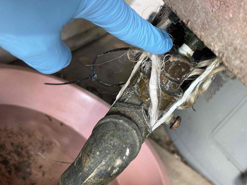 Responded to water leak call for boiler system located in laundry room. Upon inspection, found severely corroded pressure relief valve with active leaking, requiring bucket placement to catch discharge. Removed deteriorated pressure relief valve showing significant mineral deposits and oxidation, then installed new replacement valve with proper threading and sealing to eliminate leak and restore safe boiler operation.
