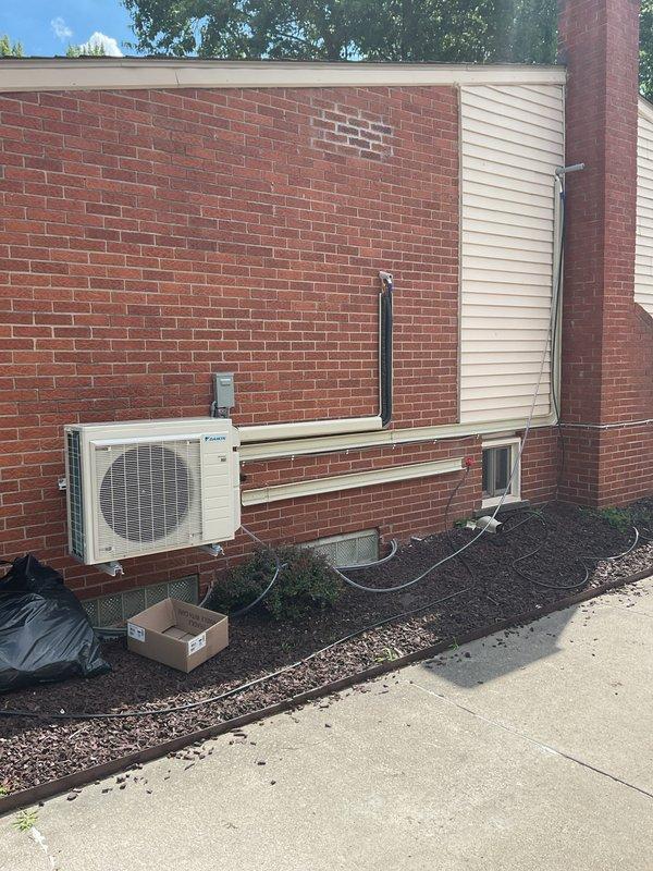 Completed full multi-zone mini split system installation over a five-day period, including two outdoor Daikin condensing units mounted on brick foundation with corresponding indoor air handlers. Ran refrigerant line sets with protective covers, installed new electrical circuit and conduit routing, and completed all mechanical and electrical connections per manufacturer specifications. System tested and operational with all components properly secured, landscaping restored, and installation site cleared of debris.