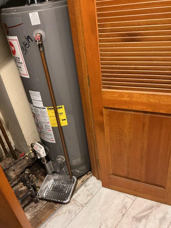 Replaced leaking 50-gallon standard natural draft water heater in residential utility closet. Removed existing unit that was actively leaking and causing significant water damage to surrounding floor substrate. Installed new 50-gallon residential water heater with proper venting configuration, reconnected copper supply lines with shutoff valves, and established gas connections. Installed required drip pan beneath unit to meet code compliance and prevent future water damage. Verified all connections for proper operation, tested temperature and pressure relief valve functionality, and confirmed adequate draft through exhaust venting system. Unit tested and operational upon completion.