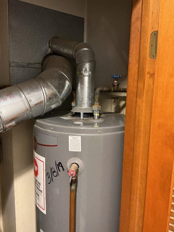 Replaced leaking 50-gallon standard natural draft water heater in residential utility closet. Removed existing unit that was actively leaking and causing significant water damage to surrounding floor substrate. Installed new 50-gallon residential water heater with proper venting configuration, reconnected copper supply lines with shutoff valves, and established gas connections. Installed required drip pan beneath unit to meet code compliance and prevent future water damage. Verified all connections for proper operation, tested temperature and pressure relief valve functionality, and confirmed adequate draft through exhaust venting system. Unit tested and operational upon completion.