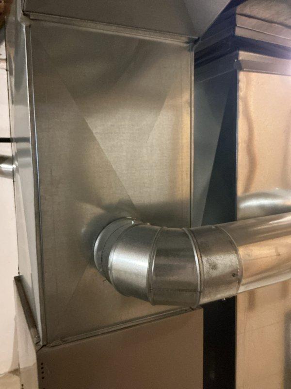 Provided estimate for air conditioning unit replacement in residential basement mechanical room. Assessed existing HVAC infrastructure including galvanized ductwork with 90-degree elbow connections, air handler unit, and associated copper refrigerant lines and PVC condensate drainage. Documented current equipment configuration and ductwork layout to determine proper sizing and installation requirements for new AC system replacement.
