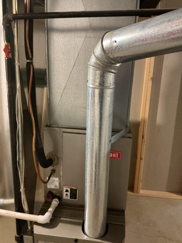Provided estimate for air conditioning unit replacement in residential basement mechanical room. Assessed existing HVAC infrastructure including galvanized ductwork with 90-degree elbow connections, air handler unit, and associated copper refrigerant lines and PVC condensate drainage. Documented current equipment configuration and ductwork layout to determine proper sizing and installation requirements for new AC system replacement.