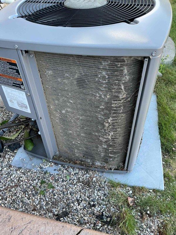 Responded to no cooling complaint on residential air conditioning system. Upon inspection, found condenser coil heavily obstructed with cottonwood seed debris and organic material, restricting airflow through the aluminum fins. Cleaned and cleared all foreign material from condenser coil using appropriate methods to restore proper airflow. Verified fan operation and unit functionality after cleaning. System restored to normal cooling operation.
