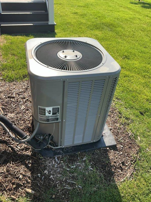 Completed Gold AC Inspection on a 4-year-old residential air conditioning system with air handler located in basement and condenser unit positioned on concrete pad in yard. Performed comprehensive multi-point inspection including visual assessment of outdoor condenser unit, verified proper equipment operation, checked refrigerant lines and electrical connections, and documented equipment condition with unit showing no visible signs of damage, rust, or deterioration.