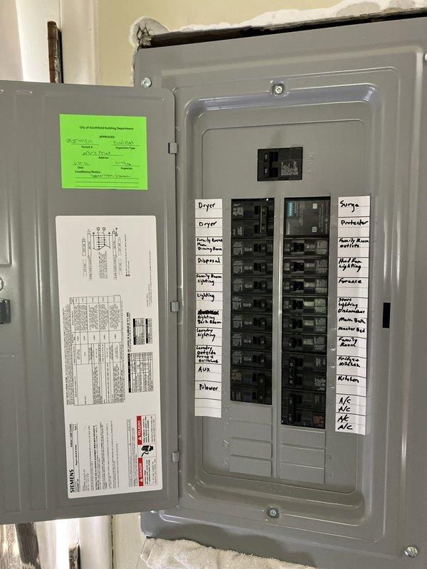 Completed HVAC system assessment for large residential cooling system replacement in attic-mounted configuration. Evaluated existing outdoor condensing unit mounted on exterior brick wall with weathered electrical disconnect and conduit installation. Inspected main electrical panel to verify circuit capacity and breaker configuration for heat pump and furnace connections. Provided estimate for Lennox vertical upflow/downflow A/C coil system suitable for 3000+ square foot application, including equipment specifications and installation requirements for attic unit location.