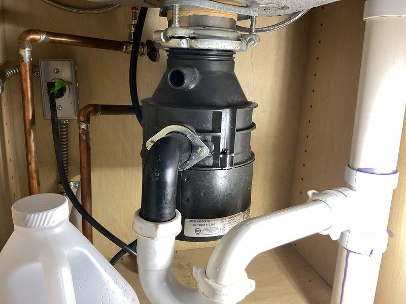 Responded to service call for malfunctioning garbage disposal and odor issue from capped gas line in former laundry closet. Inspected under-sink garbage disposal unit, including electrical connections, mounting assembly, and PVC drain configuration. Verified proper operation of disposal motor, reset mechanism, and drainage system. Addressed malfunction through troubleshooting of electrical supply and mechanical components. Examined recessed wall box in closet area containing capped water supply lines with quarter-turn ball valves for hot and cold connections. Investigated source of gas odor related to previously capped gas line where washer and dryer were formerly located. Ensured all plumbing connections were secure and functioning properly. Restored garbage disposal to full working order and addressed ventilation concerns in closet area.