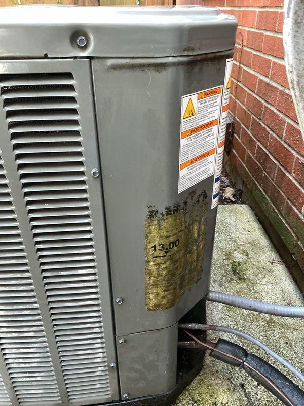 # Gold AC Inspection - HVAC Maintenance

Completed comprehensive air conditioning tune-up and inspection under plan membership. Performed thorough examination of outdoor condensing unit, including evaluation of refrigerant lines, electrical connections, and overall system condition.

## Inspection Findings

Outdoor unit exhibited moderate weathering consistent with age and environmental exposure. Copper refrigerant lines showed surface oxidation and corrosion typical of older systems. Significant debris accumulation observed within unit cabinet, including leaves, dirt, and spider webs around refrigerant line connections and internal components. Black insulation on refrigerant lines displayed deterioration and displacement in multiple areas.

Unit exterior showed substantial staining and discoloration on side panel, indicating possible water intrusion or biological growth. Concrete pad displayed heavy algae and moss growth, suggesting inadequate drainage or moisture retention. Equipment