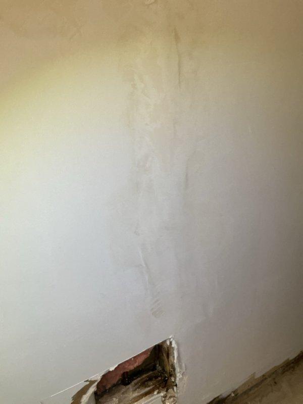 Responded to water leak originating from humidifier installation located in attic over garage. Upon inspection, discovered active leak had caused significant water damage to interior wall and structural framing. Documented extensive water staining, compromised drywall, and moisture damage to wooden structural members with visible discoloration and deterioration. Exploratory opening revealed darkened framing and saturated building materials at base of affected wall. Traced leak source to one-year-old humidifier unit and identified improper installation as root cause of water intrusion. Shut down humidifier system to prevent further damage and recommended immediate remediation of affected areas and reinstallation per manufacturer specifications.